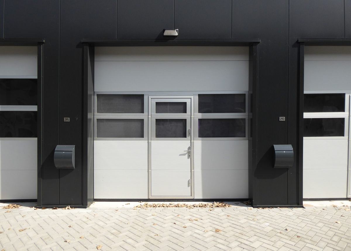 Modern roller garage door on a dark clad building