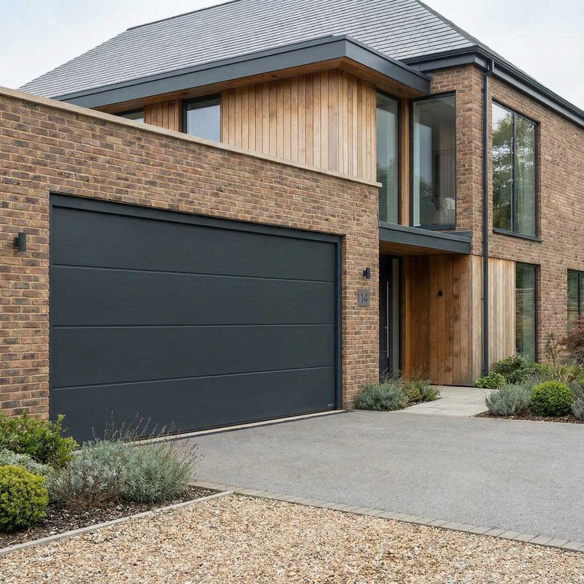 Modern brick house with a dark garage door and resin driveway